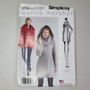 May include: Simplicity sewing pattern 1254 by Leanne Marshall for sizes 4, 6, 8, 10, 12. The envelope features illustrations of a hooded coat and a jacket with a large collar, showcasing design options for outerwear in red and grey fabric.