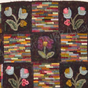 Puede incluir: Alfombra hecha a mano con un fondo marrón oscuro y un patrón de cuadrícula. Cada cuadrado presenta un diseño diferente, incluyendo rayas verticales coloridas y motivos florales en tonos de rojo, rosa, azul y amarillo. La alfombra tiene una estética rústica y artesanal.