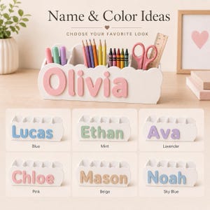 Peut inclure: Un organisateur de bureau blanc &agrave; bords festonn&eacute;s portant le pr&eacute;nom Olivia en lettres 3D roses. Il contient des crayons de couleur, des craies, des ciseaux et une r&egrave;gle en bois. Six exemples montrent des pr&eacute;noms en bleu, menthe, lavande, rose, beige et bleu ciel.