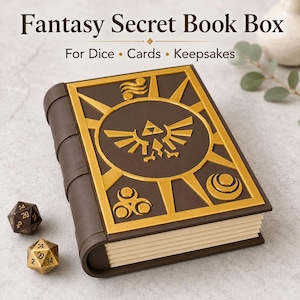 May include: A brown fantasy secret book box with gold detailing, for dice, cards, and keepsakes. The cover has a gold emblem. Two multi-sided dice are next to the book.