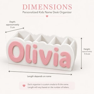 Peut inclure: Un organisateur de bureau blanc avec cinq compartiments et le nom Olivia en lettres roses en relief sur le devant. L'organisateur pr&eacute;sente un bord sup&eacute;rieur festonn&eacute;, une hauteur d'environ 7,5 cm et une profondeur d'environ 5 cm.