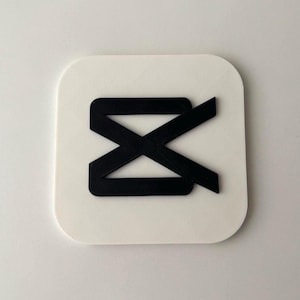 May include: A white square with rounded corners featuring a black graphic. The graphic is a stylized, overlapping design, resembling a stylized letter or symbol. The design is centered on the white square.