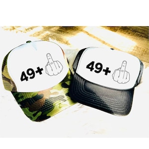 May include: Two black and white trucker hats with a white mesh back. The front of the hats have a black graphic of a middle finger and the text "49+". One hat has a camouflage pattern on the back and the other has a black back.
