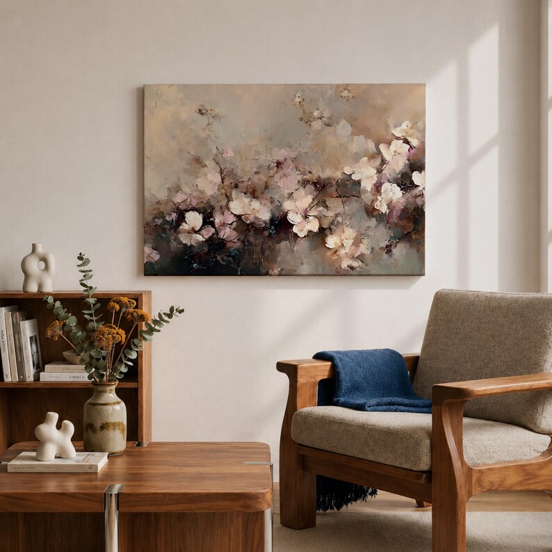 Puede incluir: Pintura floral abstracta en tonos neutros. La obra presenta flores blancas y rosas sobre un fondo beige y marr&oacute;n. Una silla y una mesa de madera est&aacute;n en primer plano.