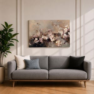 Puede incluir: Un sof&aacute; gris con patas de madera y tres cojines. Una gran pintura floral en tonos apagados de rosa, blanco y marr&oacute;n cuelga sobre el sof&aacute;. Una planta en maceta est&aacute; a la izquierda del sof&aacute;.