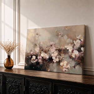 An abstract framed canvas artwork depicting cherry blossom flowers in soft, blurred tones with textured brush strokes creating a delicate floral composition that evokes the beauty of spring blooms in a modern artistic style.