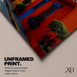 Puede incluir: Una impresi&oacute;n sin marco en papel premium que muestra una pared roja vibrante con contraventanas azules y plantas en macetas verdes. El texto dice UNFRAMED PRINT. Printed on premium paper. Shipped rolled in a tube, ready to frame. Incluye el logo XD XSCAPE DESIGNS.