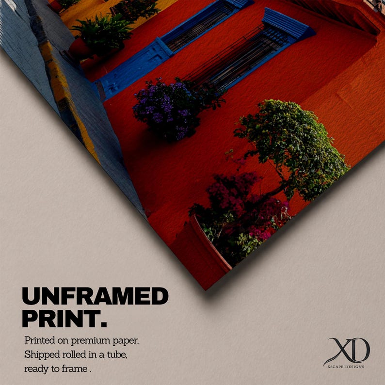 Puede incluir: Una impresi&oacute;n sin marco en papel premium que muestra una pared roja vibrante con contraventanas azules y plantas en macetas verdes. El texto dice UNFRAMED PRINT. Printed on premium paper. Shipped rolled in a tube, ready to frame. Incluye el logo XD XSCAPE DESIGNS.