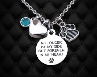 May include: Silver necklace with a heart charm, a paw print charm, and a round charm with the text "No longer by my side but forever in my heart" and a paw print. The necklace also has a teal blue gemstone.