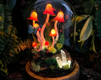 May include: A glass dome with a wooden base containing a miniature forest scene with glowing red mushrooms, green moss, and clear quartz crystals.