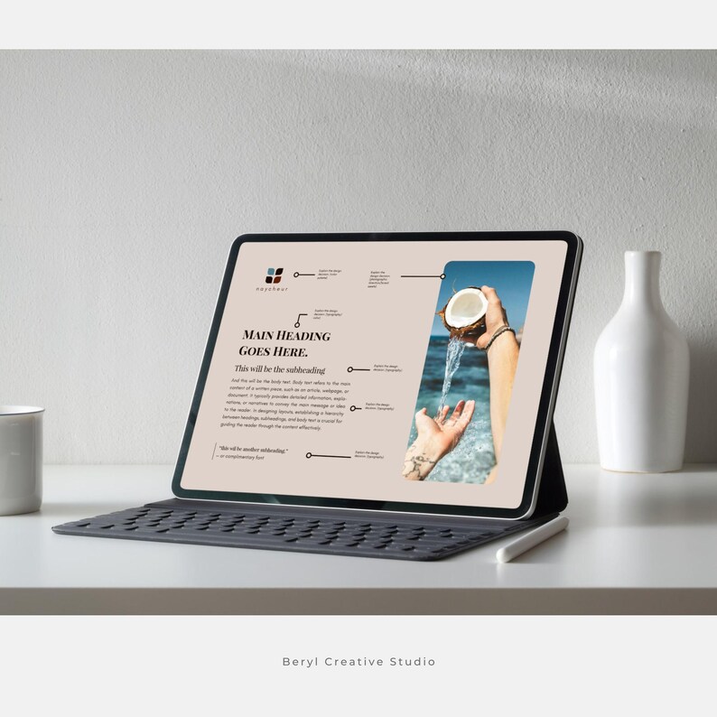 May include: A tablet computer displaying a website with a light brown background and a photo of a hand holding a coconut over a body of water. The text on the website reads "Main Heading Goes Here. This will be the subheading."