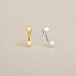 May include: A pair of earrings with two white opal stones on each earring. The earrings are available in gold and silver.