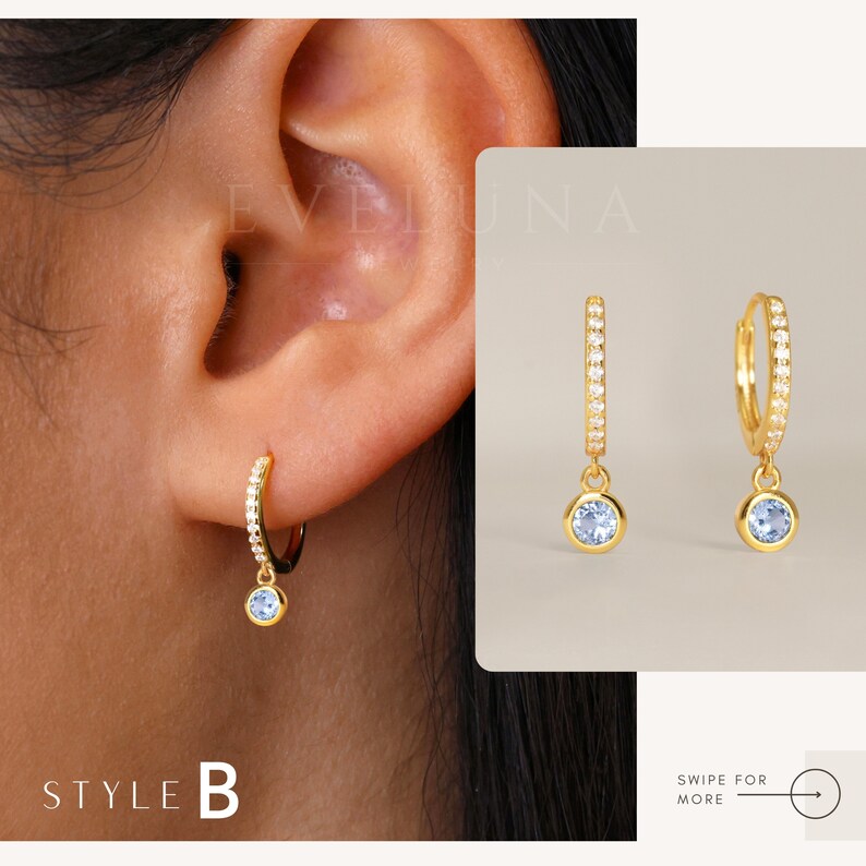 May include: Gold hoop earrings with a small blue gemstone dangling from each hoop. The hoops are lined with small clear cubic zirconia stones.  Style B.