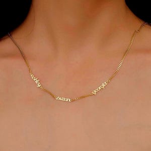 May include: Gold chain necklace with three names, "ashley", "suzan", and "georgia", spelled out in cursive.