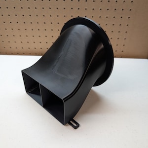 May include: A black plastic 3D printed air intake duct with a square opening and a round opening.