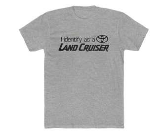 Könnte beinhalten: Ein graues T-Shirt mit dem Text "Ich identifiziere mich als ein Toyota Land Cruiser" und dem Toyota-Logo.