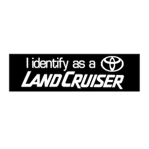 May include: Black and white sticker with the text "I identify as a LAND CRUISER" and the Toyota logo.