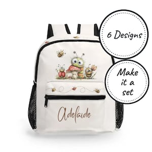 May include: A white backpack featuring a cartoon illustration of a green caterpillar, a red ladybug, and bees around a mushroom. The front pocket displays the name Adelaide in brown script. Two circular badges state 6 Designs and Make it a set.