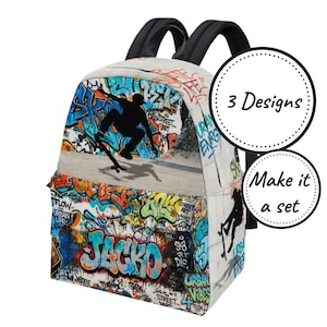 May include: A backpack featuring a vibrant graffiti print with a black silhouette of a person skateboarding. The design includes the text "JACKO" in large blue and orange letters, along with "3 Designs" and "Make it a set" in circular badges.