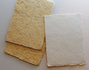 May include: Two sheets of textured, off-white paper with a yellow fleck pattern and one sheet of smooth, white paper.