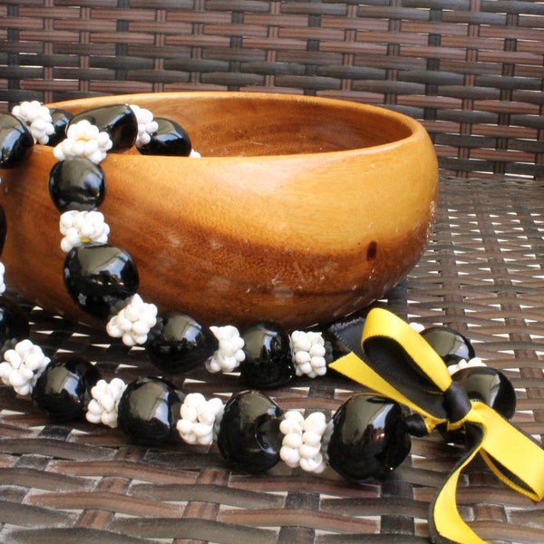 Black Kukui nut and white mongo shell lei with yellow accent ribbon