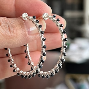 Clip-on zilverkleurige oorringen met zwarte ruggengraatkralen