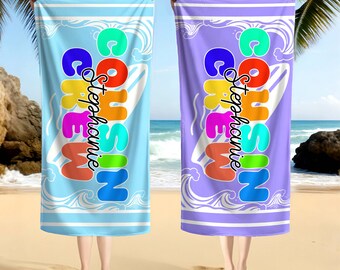 May include: Two beach towels, one light blue and one purple, are held up against a beach backdrop. Each towel features the text "COHSIN CREW Stephanie" in colorful, bold letters, with a surfboard graphic and wave design.