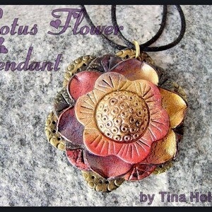 May include: A handcrafted lotus flower pendant with a black cord. The pendant features a layered design with red, gold, and bronze tones. The text "Lotus Flower Pendant" is visible in the image.