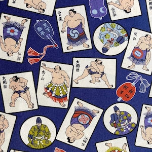 Könnte beinhalten: Ein blauer Stoff mit einem sich wiederholenden Muster aus weißen Karten, die Illustrationen von Sumo-Ringer in verschiedenen Posen zeigen. Die Karten haben japanischen Text, darunter "天下泰平" (bedeutet "Frieden in der Welt") und "大相撲" (bedeutet "Großes Sumo").