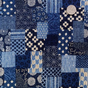 Peut inclure: Tissu patchwork aux motifs bleus variés, incluant des motifs floraux, géométriques et à pois. Le tissu présente des nuances d'indigo, de bleu clair et de crème. Une pièce de monnaie est incluse pour l'échelle.