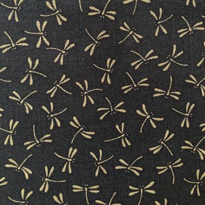 May include: Black fabric with a repeating pattern of gold dragonfly silhouettes.