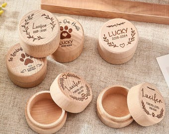 May include: Set of six wooden boxes with engraved paw prints and names. The boxes are in various shades of brown and have a natural wood finish. The text on the boxes includes "In Loving Memory", "Lucifen", "Lucky", and "Forever Loved".