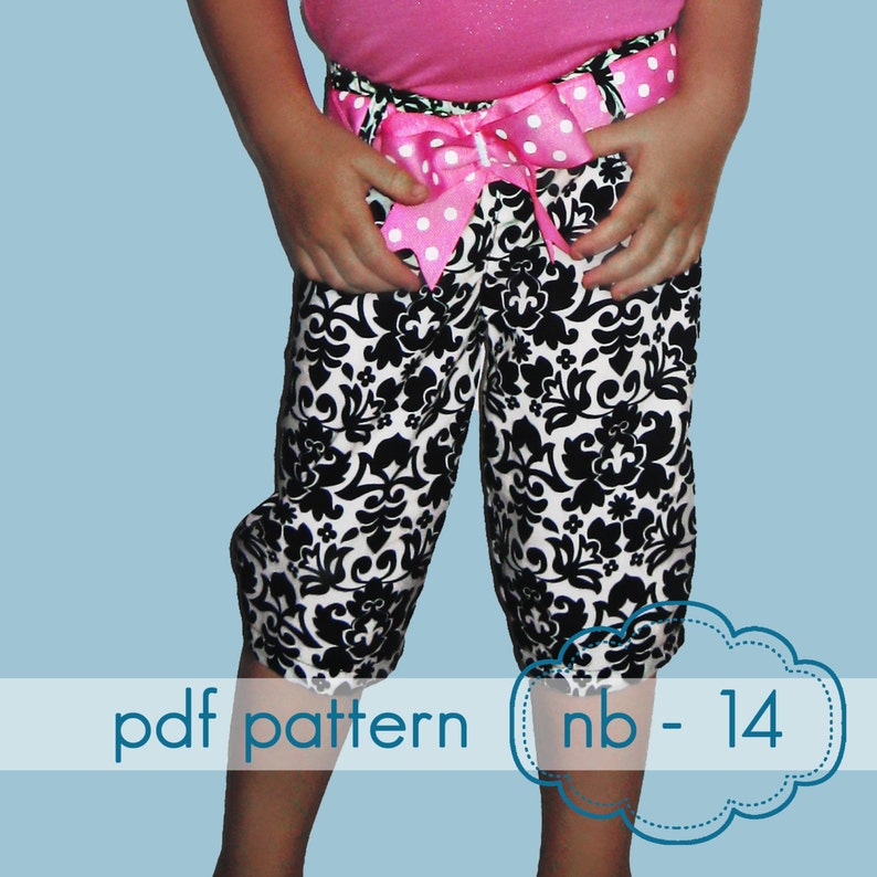 Puede incluir: Pantalones capri con estampado floral en blanco y negro, un lazo rosa y una parte superior rosa. El texto "pdf pattern nb - 14" es visible. Los pantalones tienen un ribete decorativo en el dobladillo.