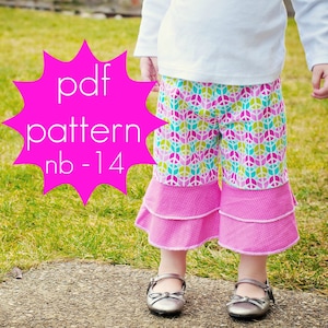 Può includere: Un paio di pantaloni colorati con orlo a balze rosa. I pantaloni presentano un motivo con il simbolo della pace nei toni del rosa, verde e blu. L'immagine include anche il testo "pdf pattern nb-14" in una stella rosa.