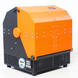 May include: A black and orange industrial machine with a digital display and a vent on the side. The machine has a black base with a grid pattern and a black handle.