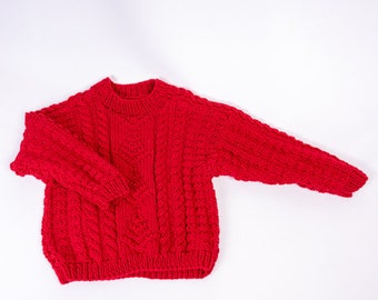 Handgestrickter Kinderpullover mit Zöpfen