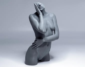 May include: A gray sculpture of a torso with the head and upper body of a person. The figure's left hand is touching the face, and the right hand is resting on the hip. The sculpture is on a white surface.