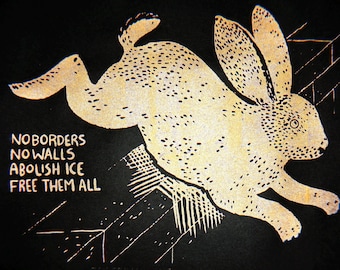 Test Print No Borders No Walls Abolish Ice Free Them All -- gold bunny screenprint on black paper, migration liberation, Minneapolis protest
