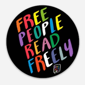 Puede incluir: Una pegatina redonda en blanco y negro con las palabras "FREE PEOPLE READ FREELY" escritas en un arcoíris de colores. Las palabras están escritas en diagonal y el texto "ROCKET SHIP" está en un pequeño bocadillo en la parte inferior.