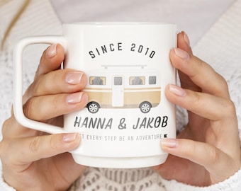May include: White ceramic mug with a brown and white illustration of a camper van. The mug has the text "SINCE 2010" and "HANNA & JAKOB" printed on it. The text "LET EVERY STEP BE AN ADVENTURE" is printed below the names.