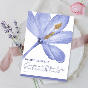 May include: A greeting card with a watercolor illustration of a light purple flower. The card has text in German that reads "DU BIST DIE BESTE!" and a quote. A sprig of lavender and a pink rose are also visible.