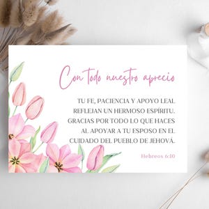 Peut inclure: Une carte blanche avec un motif floral à l'aquarelle représentant des tulipes roses et des feuilles vertes. La carte contient du texte en espagnol, dont "Con todo nuestro aprecio".