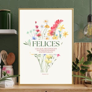 Könnte beinhalten: Ein gerahmter Kunstdruck mit einem Aquarell-Blumenarrangement in Rot-, Gelb-, Rosa- und Blautönen. Das Wort "FELICES" ist grün dargestellt, darunter spanischer Text. Der Druck hat einen weißen Hintergrund.