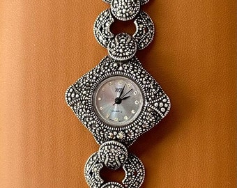 Reloj plateado de diseño especial para mujer.