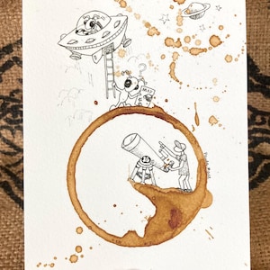 May include: A whimsical ink and coffee stain illustration depicts a UFO landing, aliens with a map, and figures observing the sky with a telescope. The artwork features a brown coffee ring and splatters, with the artist's signature in the corner.