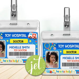 May include: Two clear plastic ID badges with metal clips. Each badge features a photo of a young girl, the text "TOY HOSPITAL DOCTOR," and the name "MICHELLE SMITH." The badges have a blue background with medical-themed graphics.