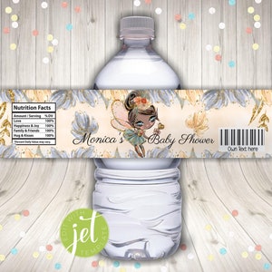Puede incluir: Etiqueta de botella de agua con un diseño floral dorado y azul. La etiqueta presenta un hada de dibujos animados con piel morena y una corona. El texto en la etiqueta dice "Monica's Baby Shower" y "Own Text here".