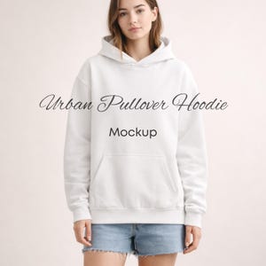 May include: A white Urban Pullover Hoodie mockup with a front pocket and a hood. The text "Urban Pullover Hoodie" and "Mockup" are displayed on the hoodie. The model is wearing blue jean shorts.