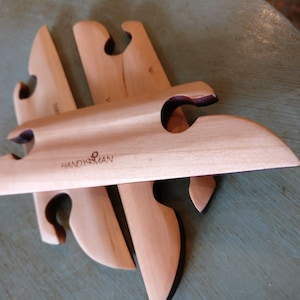 May include: Three wooden knitting needles with a unique design and the text "HANDYSMAN" engraved on the top needle.