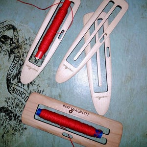 Lanzadera de barco delgada para tejido de bandas